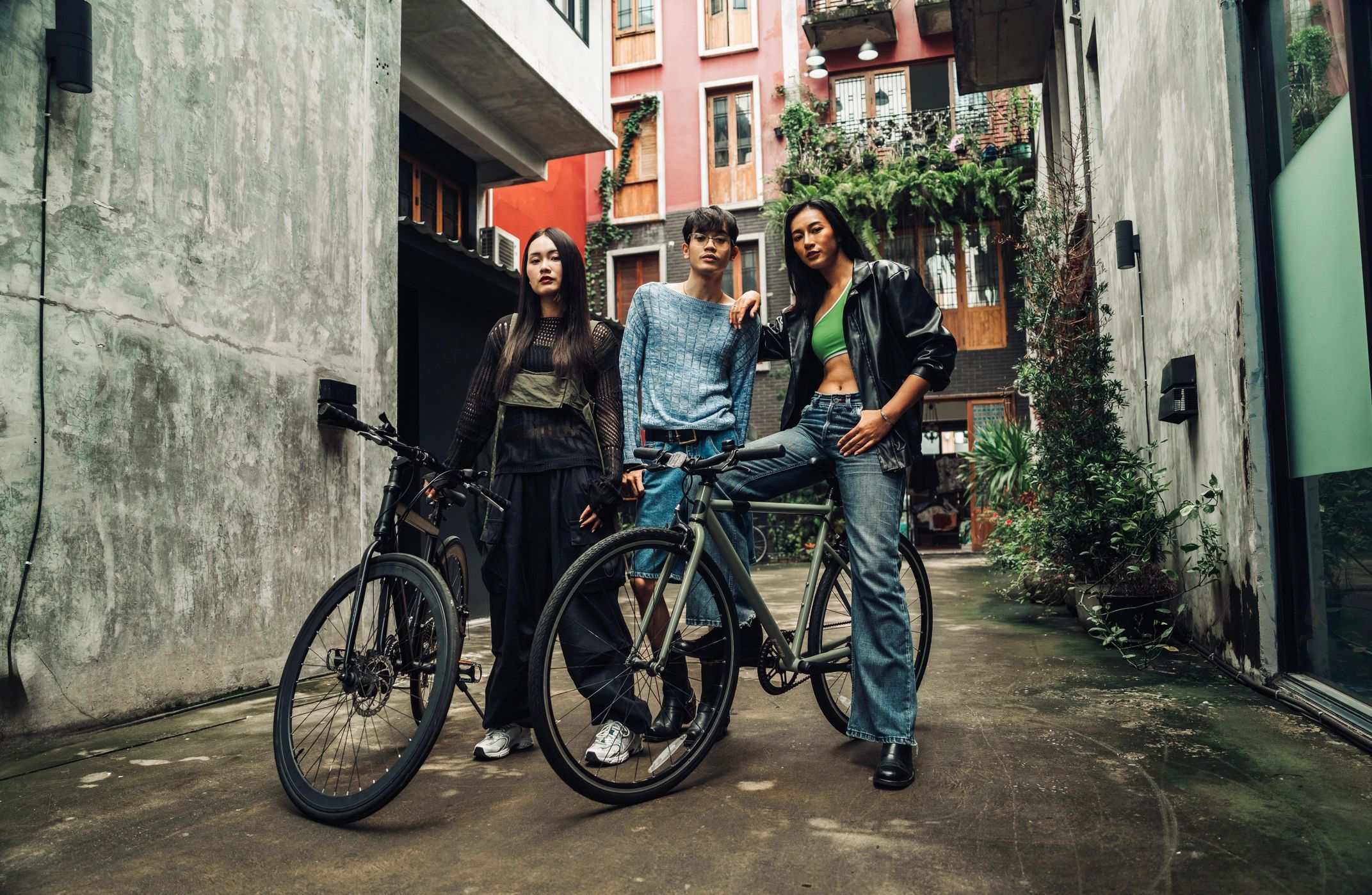 Friends with bicycles gathered in an urban alley for a themed meetup